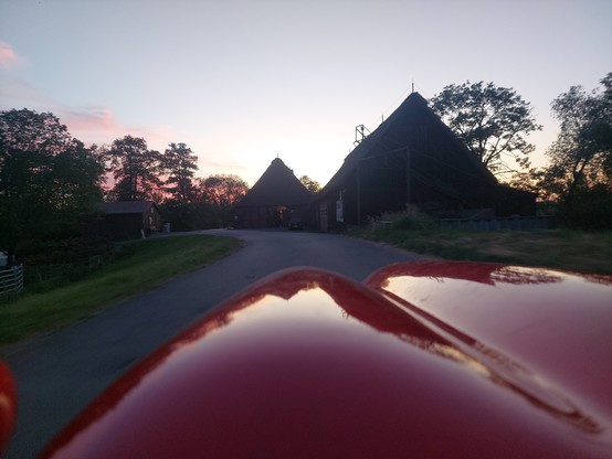 Reet gedeckte Scheunen und Bauernhäuser im Gegenlicht der untergehenden Sonne spiegeln sich auf meinem Velomobil