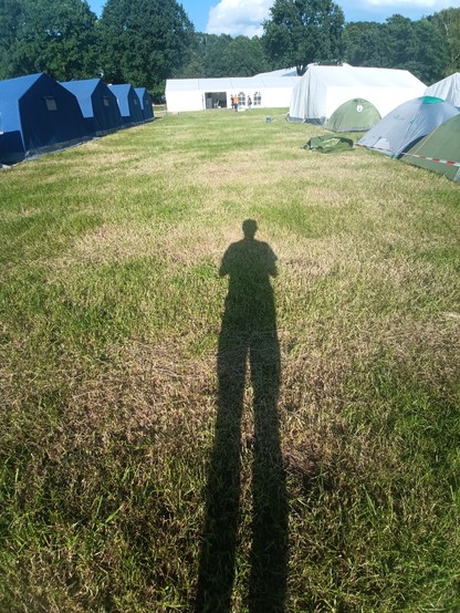 Riesiger Schatten des Fotografen vor den Mannschaftszelten.