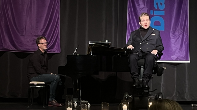 Aufnahme der Bühne: Dekanatskantor Karsten Koch am Flügel und Samuel Koch in einem selbsfahrenden Rollstuhl, den Publikum zugewandt.